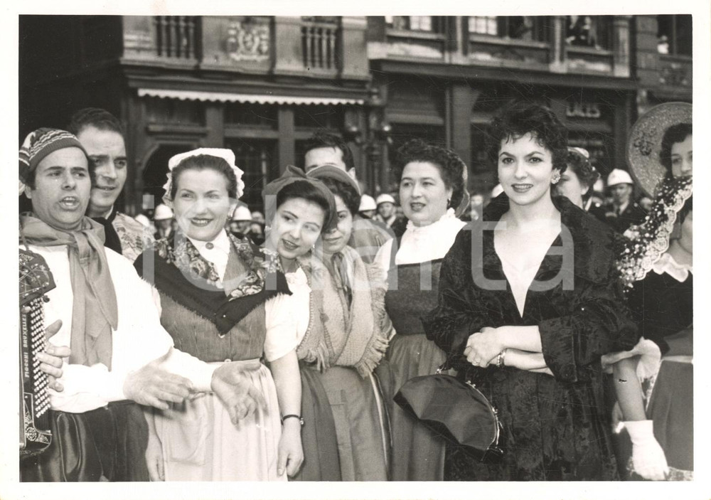 1954 BRUXELLES Gina LOLLOBRIGIDA incontra gruppo folk italiano - Foto 18x13 Fotografia d'epoca, con didascalia coeva al verso.L'attrice era in citt&agrave; per la prima di "Pane, amore e gelosia".CONDIZIONI: FAIR (lieve piegatura marginale e sovraimpressione circolare)FORMATO: 18x13 cm    originale e autentica 1