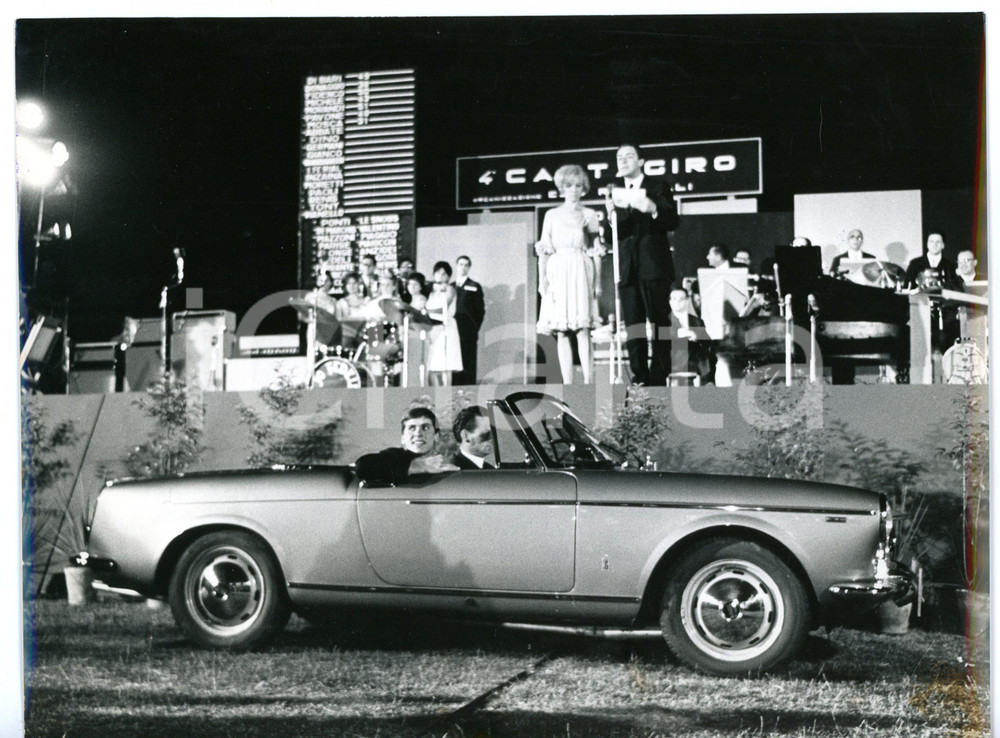 1965 IV CANTAGIRO Gianni MORANDI a bordo dell'"auto tutta d'oro" *Foto 24x18 cm Fotografia d'epoca con didascalia coeva al verso. CONDIZIONI: FAIR (bassa qualit&agrave; di stampa)FORMATO: 24x18 cm     originale e autentica 1