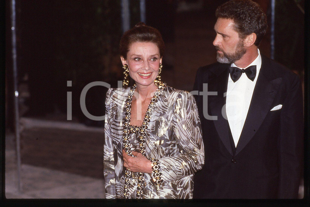 35mm vintage slide* 1985 ca CINEMA Audrey HEPBURN and Rob WOLDERS  Diapositiva d'epoca, in formato 35 mm.CONDIZIONI: GOODE' severamente vietata la riproduzione. Tutti i diritti sono riservati.Nella diapositiva ICharta mette in vendita, sul negozio eBay e in esclusiva sul sito "icharta" il proprio archivio composto da numerose diapositive e negativi fotografici d'epoca, tutti originali e autentici, che attraversano la storia del costume italiano tra gli la fine degli anni Sessanta e Novanta.Si tratta di uno sguardo inedito sull'attualit&agrave;, la politica, la vita quotidiana, il gossip e la cultura, che fotografa il cambiamento della nazione in quest'ultimo scorcio del XX secolo. Un'occasione unica per il mercato del collezionismo, che vede finalmente disponibile un archivio eccezionale per vastit&agrave;, tematiche e condizioni, in un settore (il negativo fotografico e la diapositiva) di assoluta novit&agrave; e dalle interessanti prospettive di investimento. GOOD/buono   originale e autentica 1