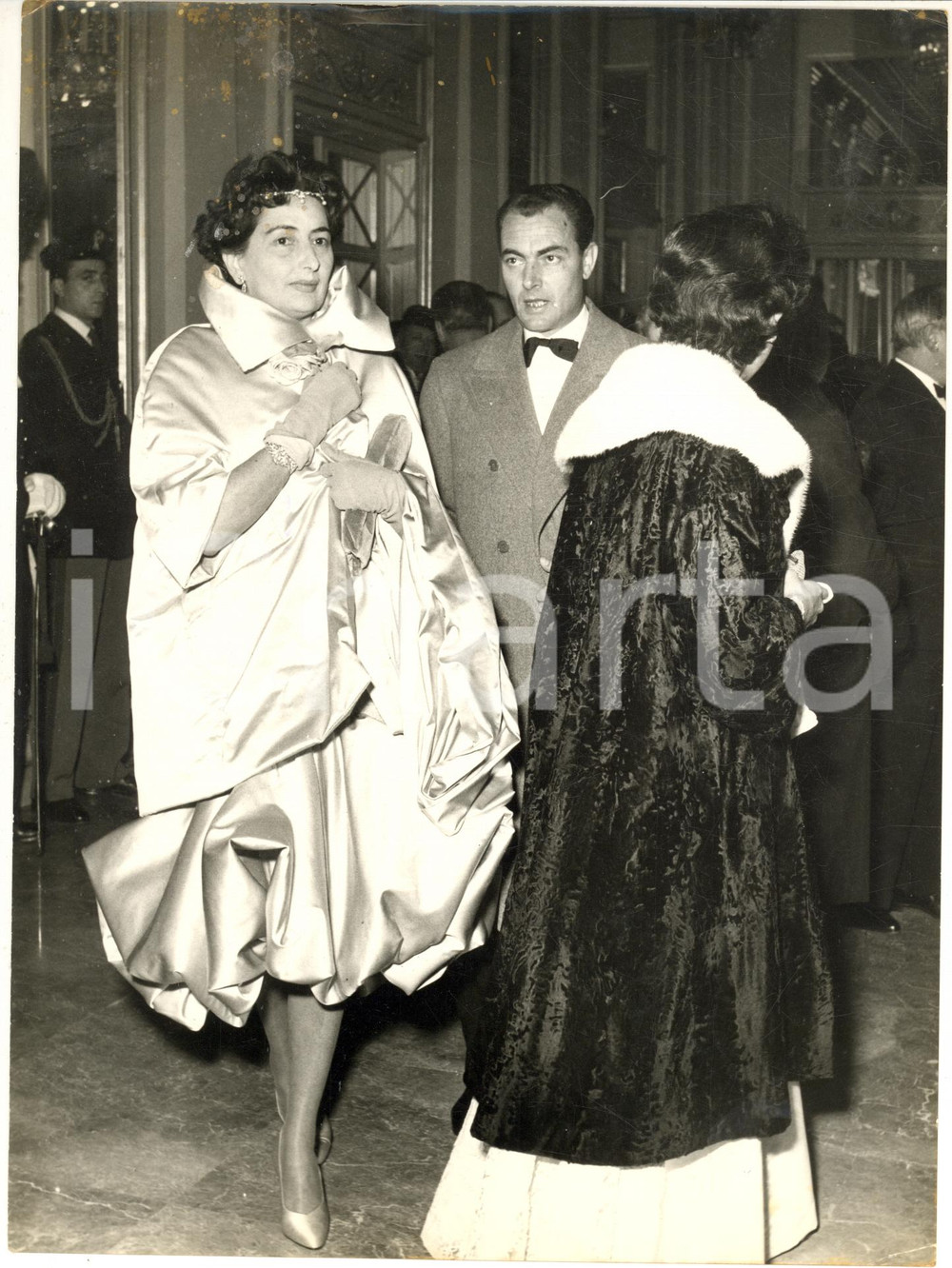 1958 MILANO Teatro alla Scala - Aldo CAMPATELLI alla prima con la moglie Lucy Fotografia d'epoca con didascalia coeva.CONDIZIONI: poor (lieve piegatura marginale e danni da umidit&agrave; al margine superiore)FORMATO: 18x24 cm    originale e autentica 1