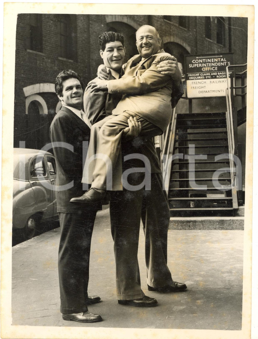 1955 LONDON World tallest boxer Ewart POTGIETER lifts up Jack SOLOMONS *Photo