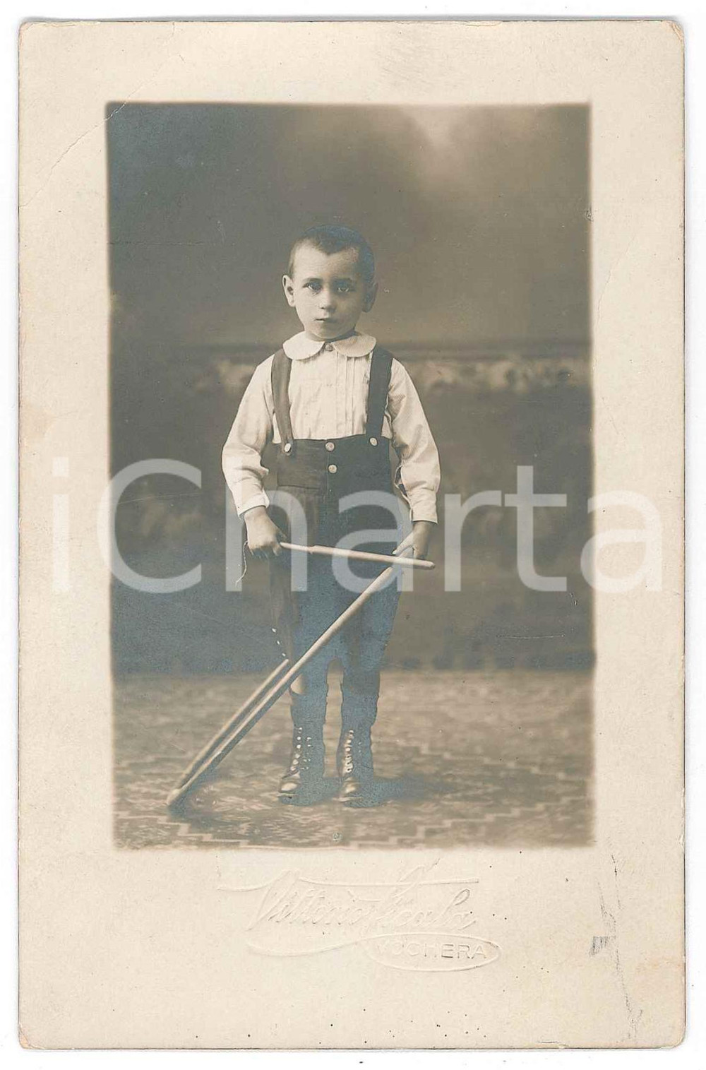 1900 ca VOGHERA Bambino con bastoni - Fotografia Vittorio CICALA 13x8 cm  Fotografia d'epoca in formato cartolina postale.Con timbro a secco del fotografo. FAIR/discreto Lievi smussature agli angoli, abrasioni al verso Formato: 8x13 originale e autentica 1