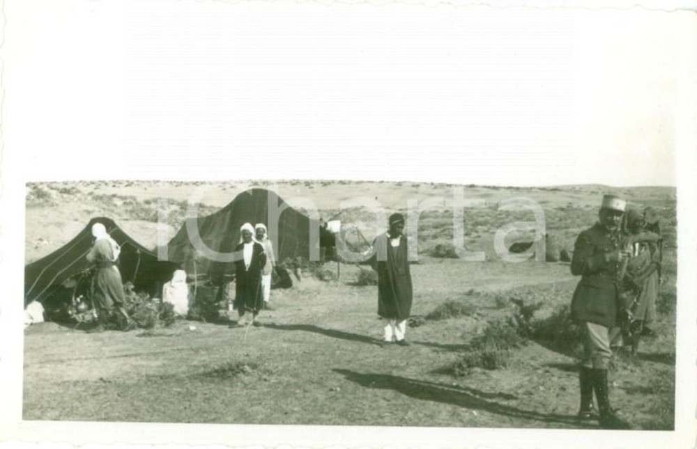 1935 ca TRIPOLI (LIBIA) Bivacco di indigeni nel deserto con ufficiale coloniale DATA: 1935 circaLUOGO: s.l., ma TRIPOLI (LIBIA)TITOLO: BIVACCO DI INDIGENI NEL DESERTO CON UFFICIALE COLONIALE DESCRIZIONE: Fotografia d'epoca.FORMATO: cm 11 x 7 CONDIZIONI: buone.Vera fotografia d'epoca, originale, autentica.    originale e autentica 1
