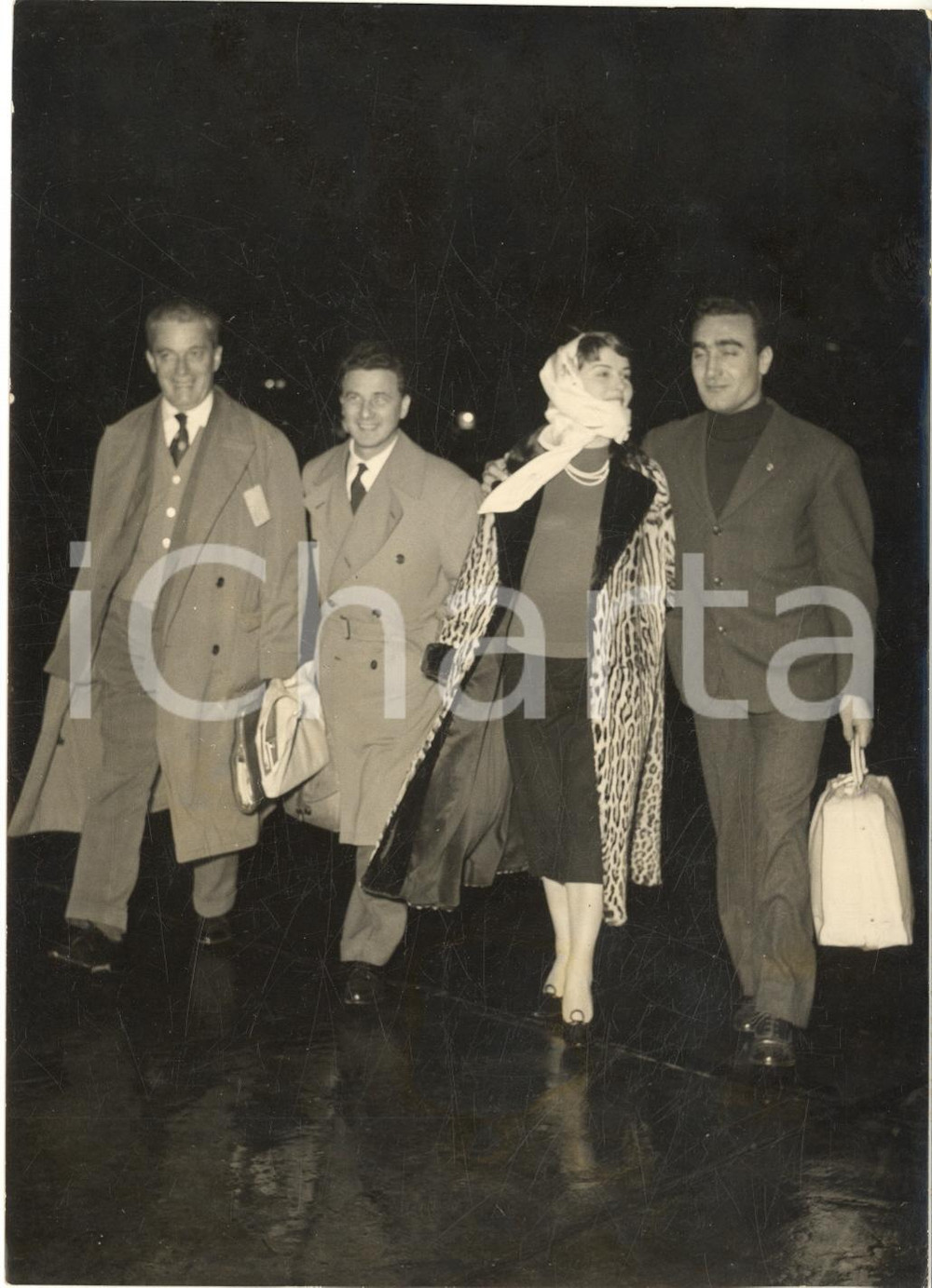 1957 ROMA Piloti FERRARI in partenza - Eugenio CASTELLOTTI con Delia SCALA Foto  Fotografia d'epoca con didascalia dattiloscritta coeva al verso.CONDIZIONI: FAIR (sovraimpressione centrale e lievi macchie in trasparenza) FORMATO:  13x18 cm    originale e autentica 1