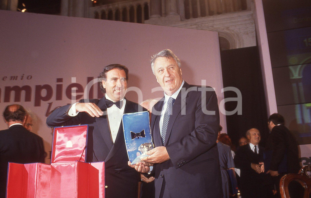 1992 Venezia PREMIO CAMPIELLO Ivano BEGGIO Sergio MALDINI *35mm vintage slide   Diapositiva originale d'epoca Tutti i diritti riservati.E' severamente vietata la riproduzione. ICharta mette in vendita, sul negozio eBay e in esclusiva sul sito "icharta" il proprio archivio composto da numerose diapositive e negativi fotografici d'epoca, tutti originali e autentici, che attraversano la storia del costume italiano tra gli la fine degli anni Sessanta e Novanta.Si tratta di uno sguardo inedito sull'attualità, la politica, la vita quotidiana, il gossip e la cultura, che fotografa il cambiamento della nazione in quest'ultimo scorcio del XX secolo. Un'occasione unica per il mercato del collezionismo, che vede finalmente disponibile un archivio eccezionale per vastità, tematiche e condizioni, in un settore (il negativo fotografico e la diapositiva) di assoluta novità e dalle interessanti prospettive di investimento. CONDIZIONI:FAIR/discretoFORMATO: 35mm originale e autentica 1