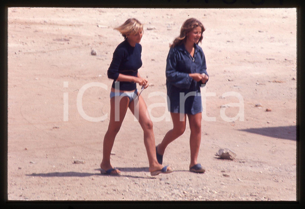 35mm vintage slide* 1974 STINTINO (SS) Maria Stella BERLINGUER paparazzata (2)  Diapositiva d'epoca, in formato 35 mm.A sinistra nella diapositiva compare Maria Stella Berlinguer, figlia di Enrico, segretario del Partito Comunista Italiano, paparazzata durante le vacanze a Stintino.  CONDIZIONI: GOOD (lievi segni superficiali nella parte superiore)Tutti i diritti riservati.E' severamente vietata la riproduzione. ICharta mette in vendita, sul negozio eBay e in esclusiva sul sito "icharta" il proprio archivio composto da numerose diapositive e negativi fotografici d'epoca, tutti originali e autentici, che attraversano la storia del costume italiano tra gli la fine degli anni Sessanta e Novanta.Si tratta di uno sguardo inedito sull'attualit&agrave;, la politica, la vita quotidiana, il gossip e la cultura, che fotografa il cambiamento della nazione in quest'ultimo scorcio del XX secolo. Un'occasione unica per il mercato del collezionismo, che vede finalmente disponibile un archivio eccezionale per vastit&agrave;, tematiche e condizioni, in un settore (il negativo fotografico e la diapositiva) di assoluta novit&agrave; e dalle interessanti prospettive di investimento.  originale e autentica 1