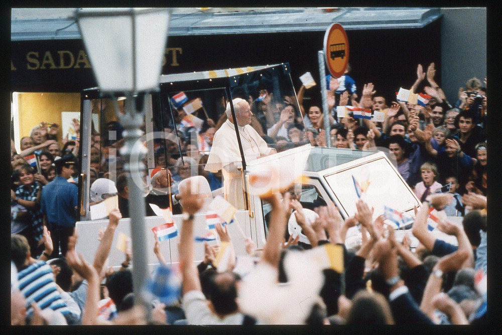 35mm vintage slide* 1994 Zagreb, Hippodrome, Giovanni Paolo II, Popemobile (2)  Diapositiva d'epoca, in formato 35 mm.CONDIZIONI: GOODE' severamente vietata la riproduzione. Tutti i diritti sono riservati.Nella diapositiva ICharta mette in vendita, sul negozio eBay e in esclusiva sul sito "icharta" il proprio archivio composto da numerose diapositive e negativi fotografici d'epoca, tutti originali e autentici, che attraversano la storia del costume italiano tra gli la fine degli anni Sessanta e Novanta.Si tratta di uno sguardo inedito sull'attualit&agrave;, la politica, la vita quotidiana, il gossip e la cultura, che fotografa il cambiamento della nazione in quest'ultimo scorcio del XX secolo. Un'occasione unica per il mercato del collezionismo, che vede finalmente disponibile un archivio eccezionale per vastit&agrave;, tematiche e condizioni, in un settore (il negativo fotografico e la diapositiva) di assoluta novit&agrave; e dalle interessanti prospettive di investimento.  FAIR/discreto   originale e autentica 1