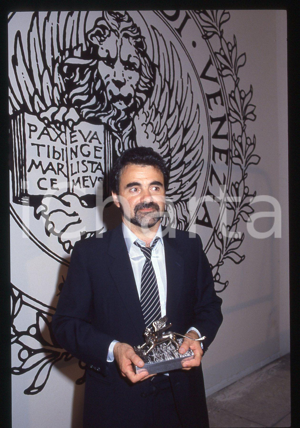 35mm vintage slide* 1986 MOSTRA DI VENEZIA Carlos SORIN con il Leone d'Argento 1  Diapositiva d'epoca, in formato 35 mm. CONDIZIONI: GOODTutti i diritti riservati.E' severamente vietata la riproduzione. ICharta mette in vendita, sul negozio eBay e in esclusiva sul sito "icharta" il proprio archivio composto da numerose diapositive e negativi fotografici d'epoca, tutti originali e autentici, che attraversano la storia del costume italiano tra gli la fine degli anni Sessanta e Novanta.Si tratta di uno sguardo inedito sull'attualit&agrave;, la politica, la vita quotidiana, il gossip e la cultura, che fotografa il cambiamento della nazione in quest'ultimo scorcio del XX secolo. Un'occasione unica per il mercato del collezionismo, che vede finalmente disponibile un archivio eccezionale per vastit&agrave;, tematiche e condizioni, in un settore (il negativo fotografico e la diapositiva) di assoluta novit&agrave; e dalle interessanti prospettive di investimento.  originale e autentica 1
