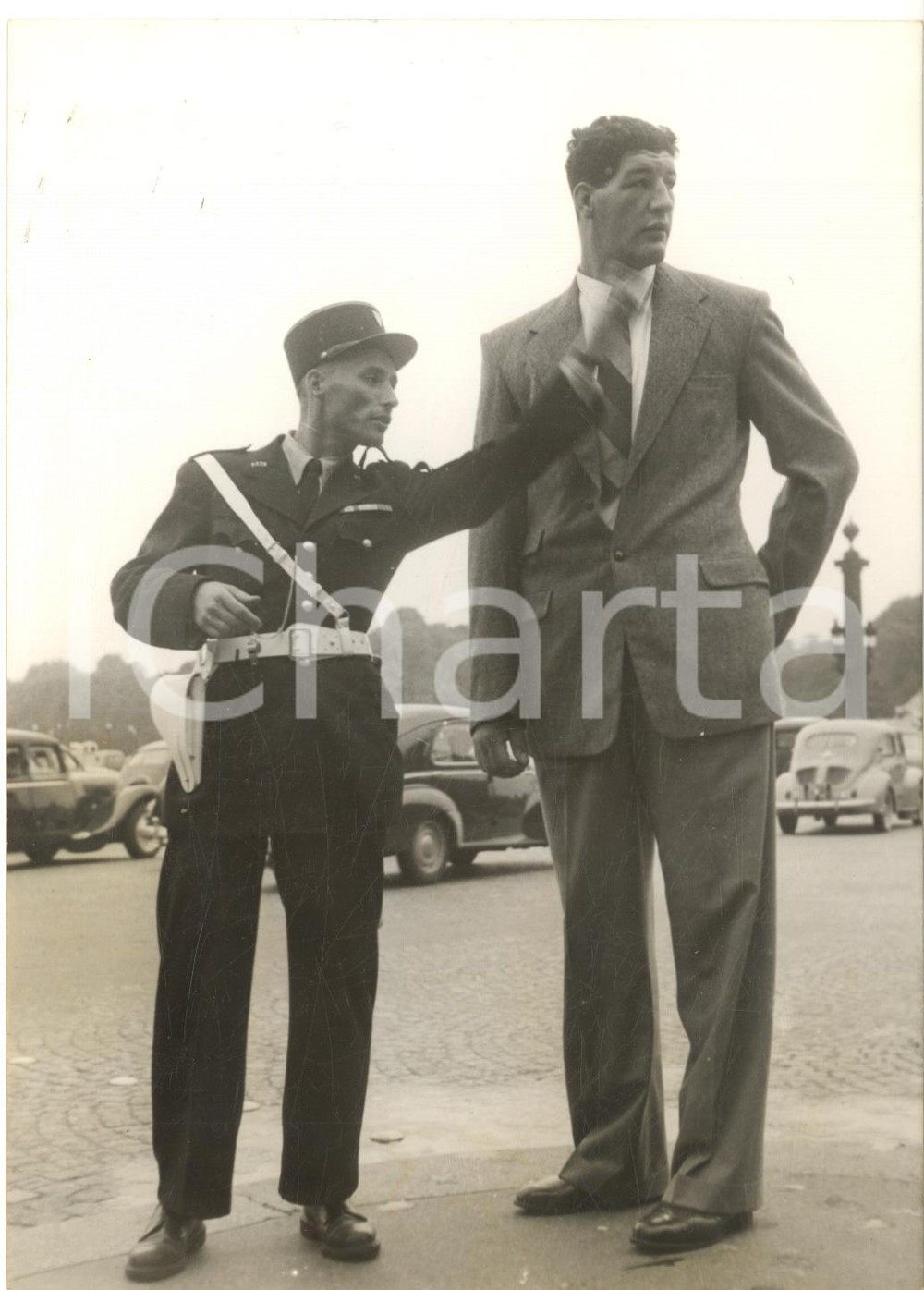 1955 PARIS Pugile gigante Ewart POTGIETER in Place de la Concorde - Foto 13x18 Fotografia d'epoca con didascalia coeva.  CONDIZIONI: G (lievi macchie al lato sinistro)FORMATO: 13x18 cm      originale e autentica 1