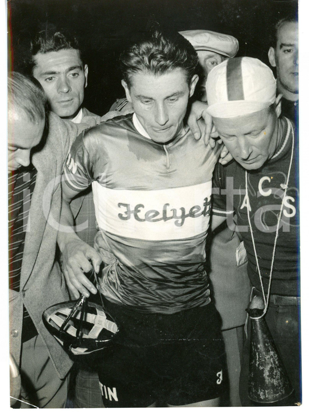 1956 MILANO CICLISMO - VIGORELLI Jacques ANQUETIL dopo tentativo record dell'ora Fotografia d'epoca con didascalia coeva.  CONDIZIONI: FAIR (piegatura all'angolo inferiore sinistro) FORMATO: 13x18 cm     originale e autentica 1