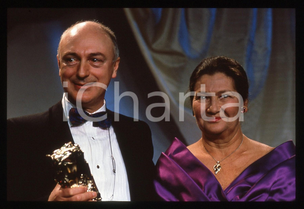 35mm vintage slide* 1989 PARIGI Percy ADLON Simone VEIL ai CESAR AWARDS (1)  Diapositiva d'epoca, in formato 35 mm.CONDIZIONI: GOOD   La diapositiva illustra Percy Adlon ai C&eacute;sar Awards del 1989, premiato per il miglior film straniero "Bagdad Caf&eacute;".Tutti i diritti riservati.E' severamente vietata la riproduzione. ICharta mette in vendita, sul negozio eBay e in esclusiva sul sito "icharta" il proprio archivio composto da numerose diapositive e negativi fotografici d'epoca, tutti originali e autentici, che attraversano la storia del costume italiano tra gli la fine degli anni Sessanta e Novanta.Si tratta di uno sguardo inedito sull'attualit&agrave;, la politica, la vita quotidiana, il gossip e la cultura, che fotografa il cambiamento della nazione in quest'ultimo scorcio del XX secolo. Un'occasione unica per il mercato del collezionismo, che vede finalmente disponibile un archivio eccezionale per vastit&agrave;, tematiche e condizioni, in un settore (il negativo fotografico e la diapositiva) di assoluta novit&agrave; e dalle interessanti prospettive di investimento.  originale e autentica 1