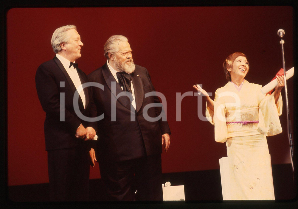 35mm vintage slide* 1983 CANNES Orson WELLES Sumiko SAKAMOTO William STYRON La diapositiva ritrae Orson Welles sul palco insieme a William Styron e a Sumiko Sakamoto per la premiazione del film The Ballad of Narayama al Festival di Cannes del 1983CONDIZIONI: GOODTutti i diritti riservati.E' severamente vietata la riproduzione. ICharta mette in vendita, sul negozio eBay e in esclusiva sul sito "icharta" il proprio archivio composto da numerose diapositive e negativi fotografici d'epoca, tutti originali e autentici, che attraversano la storia del costume italiano tra gli la fine degli anni Sessanta e Novanta.Si tratta di uno sguardo inedito sull'attualit&agrave;, la politica, la vita quotidiana, il gossip e la cultura, che fotografa il cambiamento della nazione in quest'ultimo scorcio del XX secolo. Un'occasione unica per il mercato del collezionismo, che vede finalmente disponibile un archivio eccezionale per vastit&agrave;, tematiche e condizioni, in un settore (il negativo fotografico e la diapositiva) di assoluta novit&agrave; e dalle interessanti prospettive di investimento.  originale e autentica 1