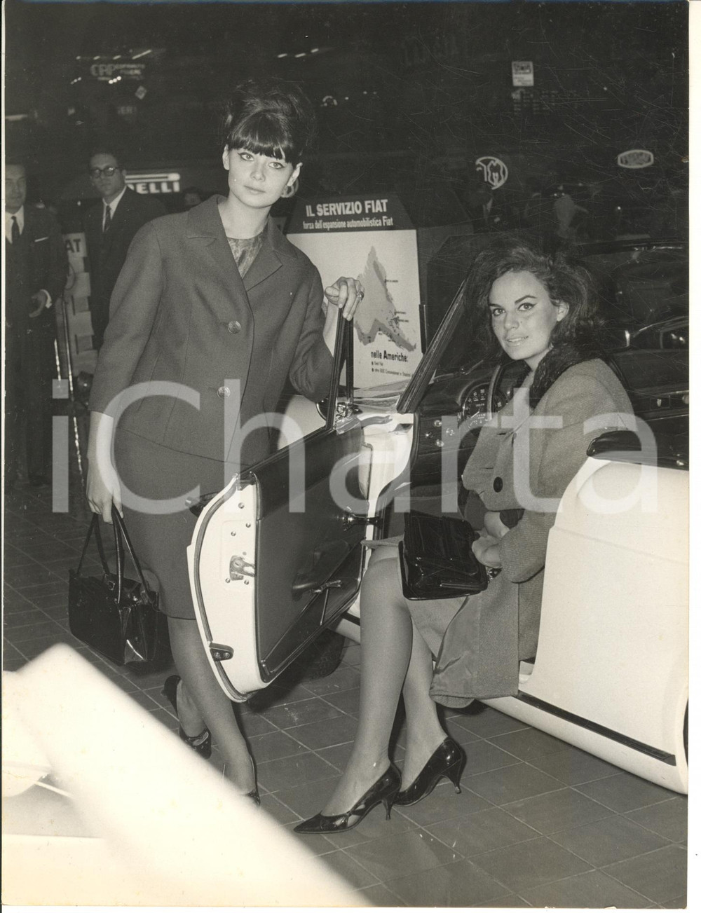 1963 TORINO Salone dell'Auto - Franca DALL'OLIO e Marina FAVA vincono FIAT 1300 Fotografia d'epoca, con didascalia dattiloscritta coeva al verso.Si tratta della consegna a Miss Italia e Miss Cinema delle vetture vinte.CONDIZIONI: FAIR (strappo di circa 1 cm al lato sinistro; lievi piegature)FORMATO: 18x24 cm      originale e autentica 1