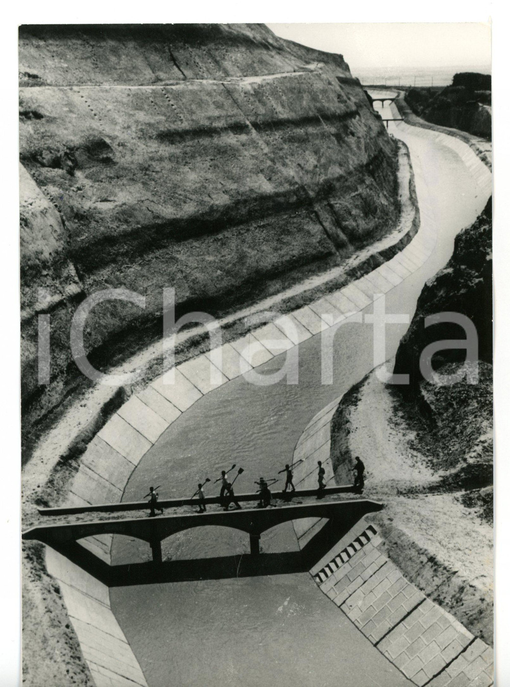 1971 SHAANXI (CINA) Braccianti attraversano canale di irrigazione *Foto 13x18 cm Fotografia d'epoca con didascalia coeva.  CONDIZIONI: G FORMATO: 13x18 cm     originale e autentica 1