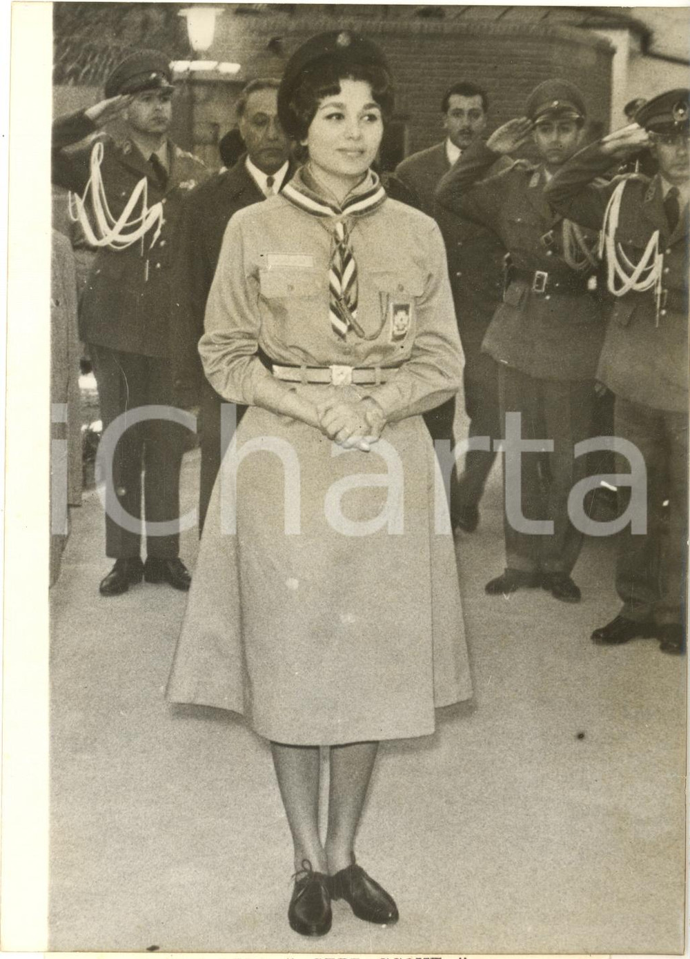 1960 s. l. Regina Farah DIBA di Persia in divisa da scout a una manifestazione Fotografia d'epoca, con didascalia coeva al verso.  CONDIZIONI: FAIR (difetti di stampa) FORMATO: 13x18 cm    originale e autentica 1