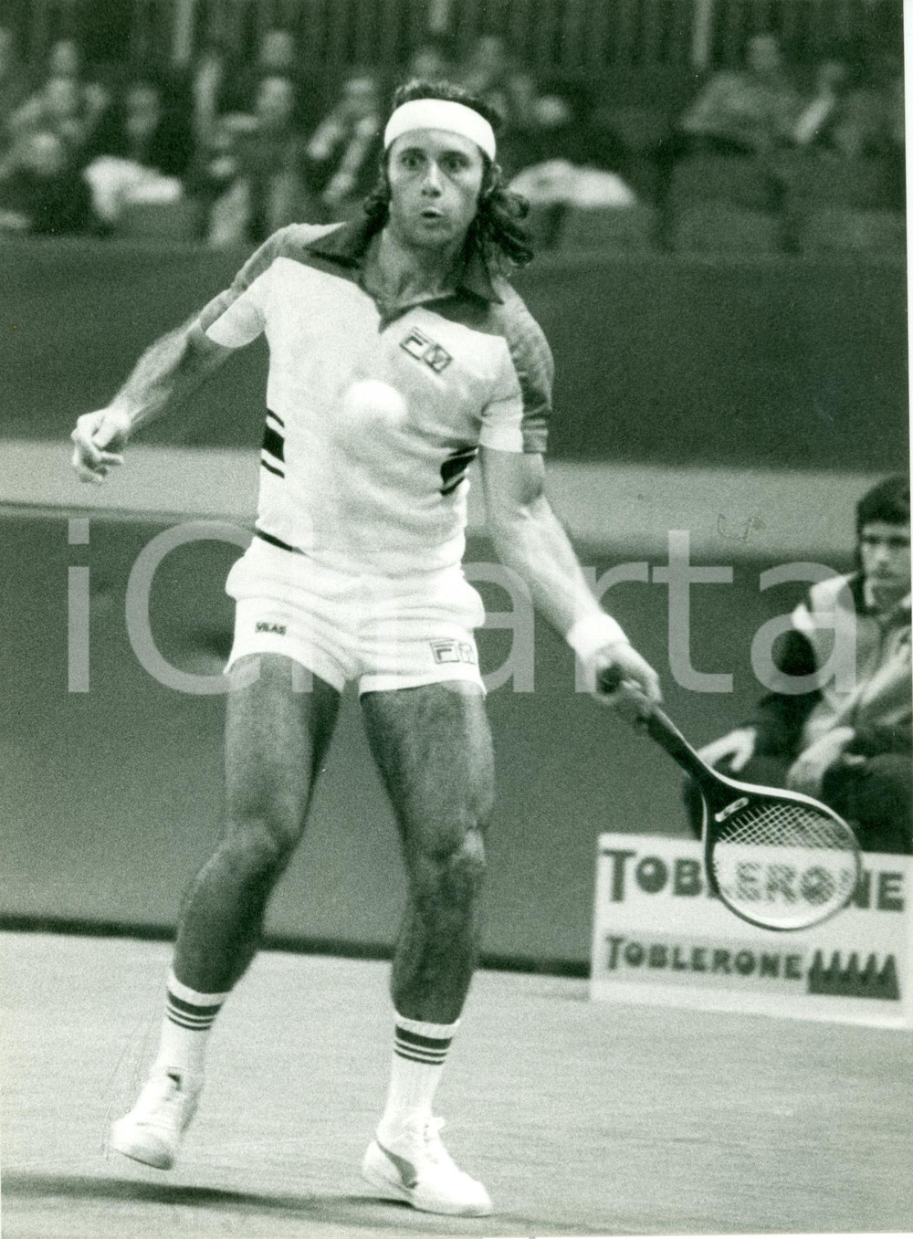 Fotografia d epoca originale 1980 ca TENNIS Campione Guillermo VILAS durante match Sponsor TOBLERONE Foto 1