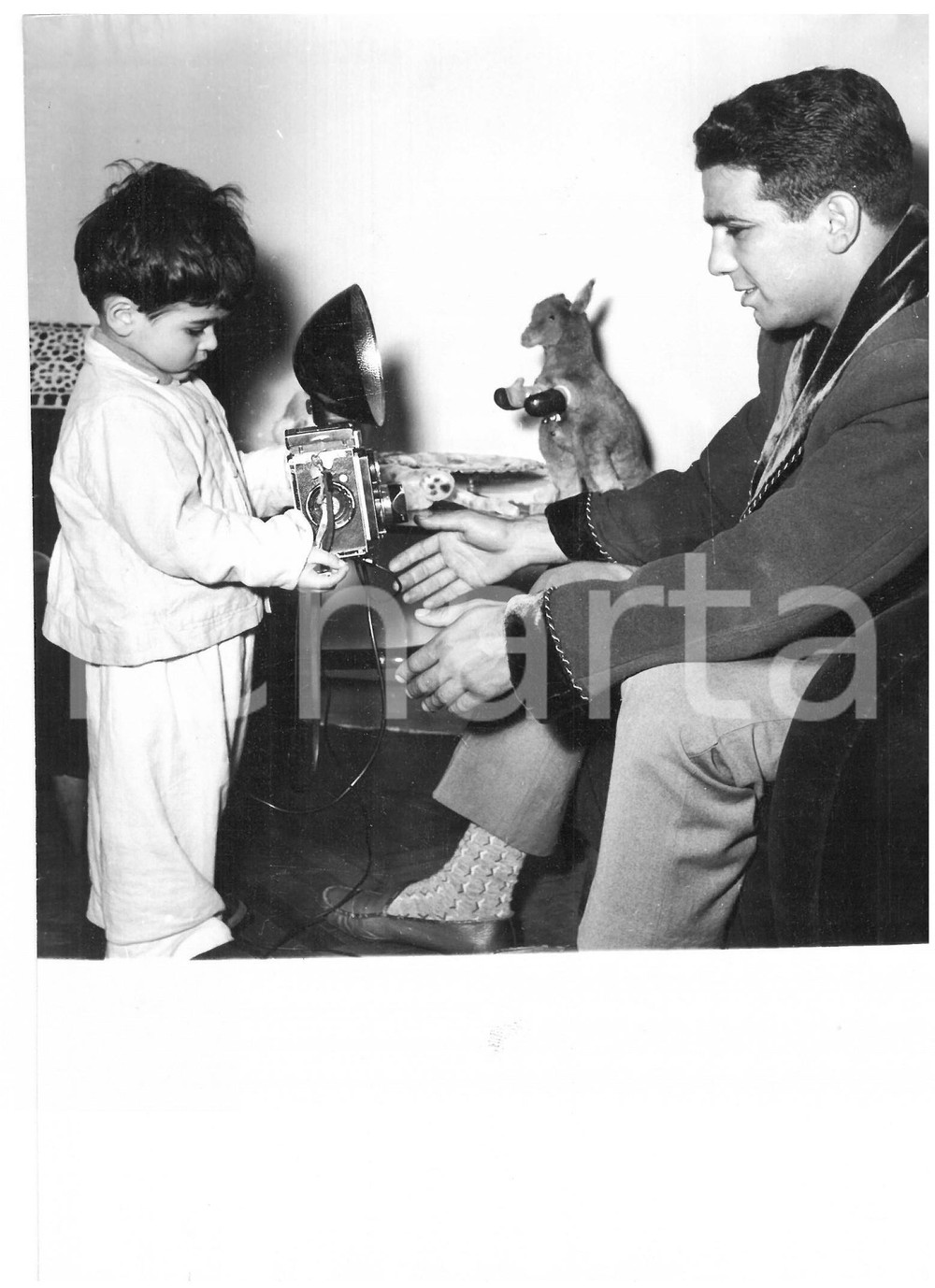 1955 GENOVA Duilio LOI gioca con suo figlio *Foto 13x18 cm Fotografia d'epoca, con didascalia coeva al verso.  CONDIZIONI: G (ma piccola piegatura al margine destro) FORMATO: 13x18 cm    originale e autentica 1