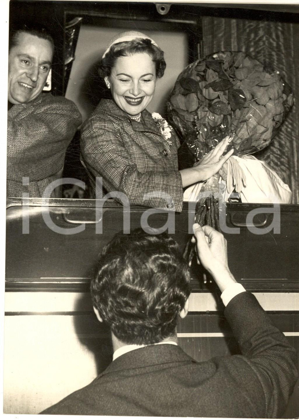 1955 ROMA Arrivo di Olivia DE HAVILLAND e Pierre GALANTE in luna di miele *Foto Fotografia d'epoca con didascalia coeva.  CONDIZIONI: G (ma lieve sovraimpressione circolare)FORMATO: 13x18 cm     originale e autentica 1