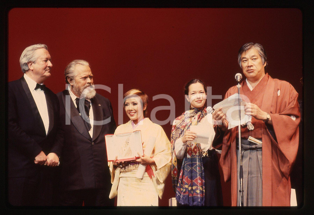 35mm vintage slide* 1983 CANNES Orson WELLES Shohei IMAMURA Sumiko SAKAMOTO La diapositiva ritrae Orson Welles sul palco insieme a William Styron, al regista di The Ballad of Narayama Shohei Imamura e all'attrice Sumiko Sakamoto per la premiazione del film al Festival di Cannes del 1983Diapositiva d'epoca, in formato 35 mm.CONDIZIONI: GOODTutti i diritti riservati.E' severamente vietata la riproduzione. ICharta mette in vendita, sul negozio eBay e in esclusiva sul sito "icharta" il proprio archivio composto da numerose diapositive e negativi fotografici d'epoca, tutti originali e autentici, che attraversano la storia del costume italiano tra gli la fine degli anni Sessanta e Novanta.Si tratta di uno sguardo inedito sull'attualit&agrave;, la politica, la vita quotidiana, il gossip e la cultura, che fotografa il cambiamento della nazione in quest'ultimo scorcio del XX secolo. Un'occasione unica per il mercato del collezionismo, che vede finalmente disponibile un archivio eccezionale per vastit&agrave;, tematiche e condizioni, in un settore (il negativo fotografico e la diapositiva) di assoluta novit&agrave; e dalle interessanti prospettive di investimento.  originale e autentica 1