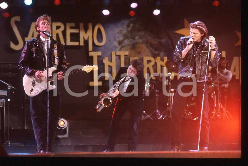 35mm vintage slide* 1991 SANREMO INTERNATIONAL Morten HARKET degli A-HA 5 Nella diapositiva compare anche Paul Waaktaar-SavoyDiapositiva d'epoca, in formato 35 mm. CONDIZIONI: GOODE' severamente vietata la riproduzione. Tutti i diritti sono riservati.Nella diapositiva ICharta mette in vendita, sul negozio eBay e in esclusiva sul sito "icharta" il proprio archivio composto da numerose diapositive e negativi fotografici d'epoca, tutti originali e autentici, che attraversano la storia del costume italiano tra gli la fine degli anni Sessanta e Novanta.Si tratta di uno sguardo inedito sull'attualit&agrave;, la politica, la vita quotidiana, il gossip e la cultura, che fotografa il cambiamento della nazione in quest'ultimo scorcio del XX secolo. Un'occasione unica per il mercato del collezionismo, che vede finalmente disponibile un archivio eccezionale per vastit&agrave;, tematiche e condizioni, in un settore (il negativo fotografico e la diapositiva) di assoluta novit&agrave; e dalle interessanti prospettive di investimento.  originale e autentica 1