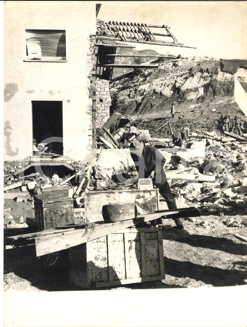 1963 TRAGEDIA DEL VAJONT Uomo presso la propria casa distrutta *Foto 18x24 cm Fotografia d'epoca con didascalia coeva.  CONDIZIONI: fair (lieve piegatura centrale)     originale e autentica 1