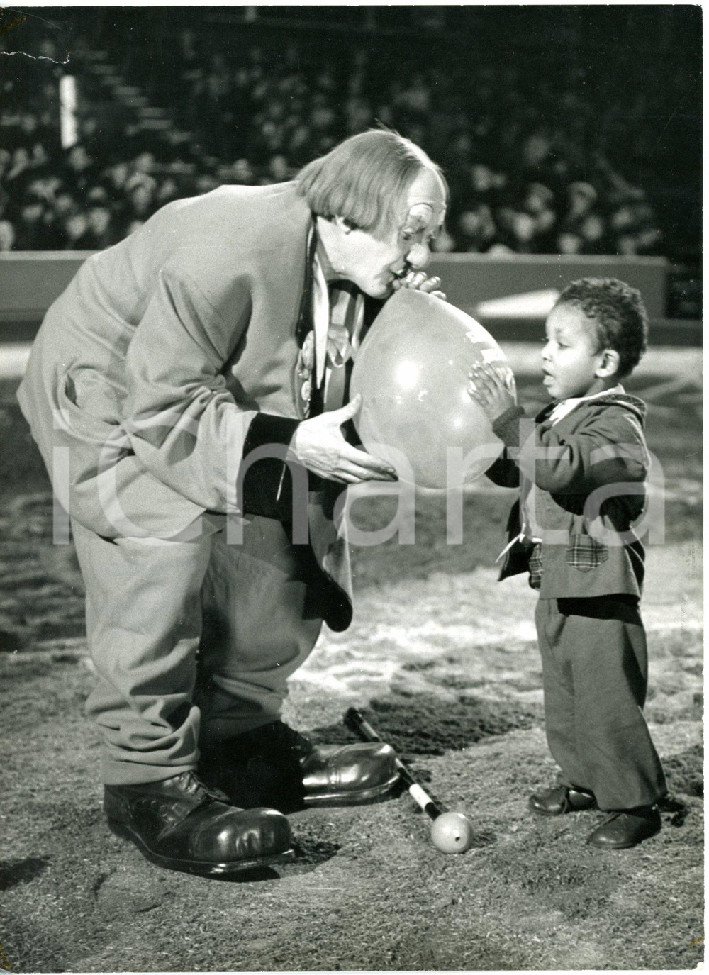 1960 LONDON Olympia - Clown COCO blowing up a balloon for a boy during rehearsal