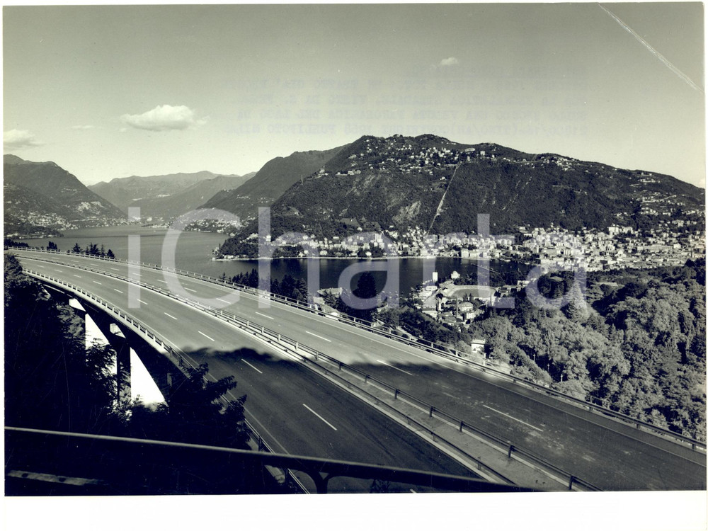 1968 SAN FERMO Veduta della nuova autostrada COMO-CHIASSO con il lago - Foto  Fotografia d'epoca con didascalia coeva.  CONDIZIONI: POOR (piegatura evidente all'angolo superiore destro, con lievi piegature al margine) FORMATO: 24x18 cm     originale e autentica 1