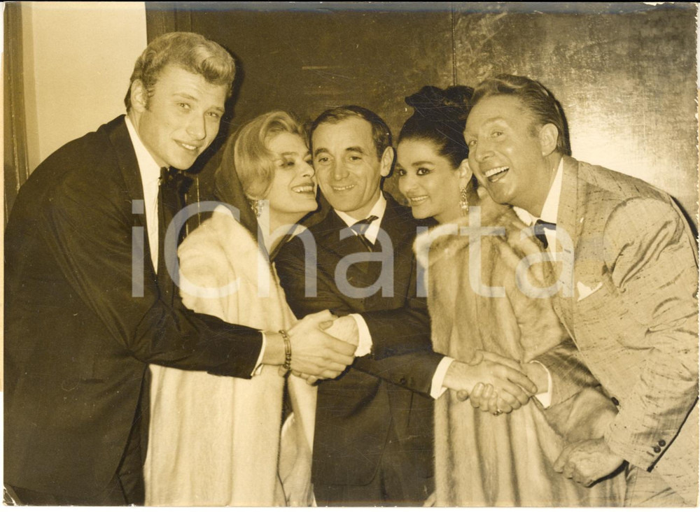 1963 PARIS OLYMPIA Charles AZNAVOUR avec Johnny HALLYDAY Charles TRENET - Photo Fotografia d'epoca con didascalia coeva, scattata in occasione del tour di Aznavour. Nella fotografia sono presenti anche Melina Mercouri e La Chunga.  CONDIZIONI: FAIR (alone diffuso e piegatura) FORMATO: 18x13 cm     originale e autentica 1
