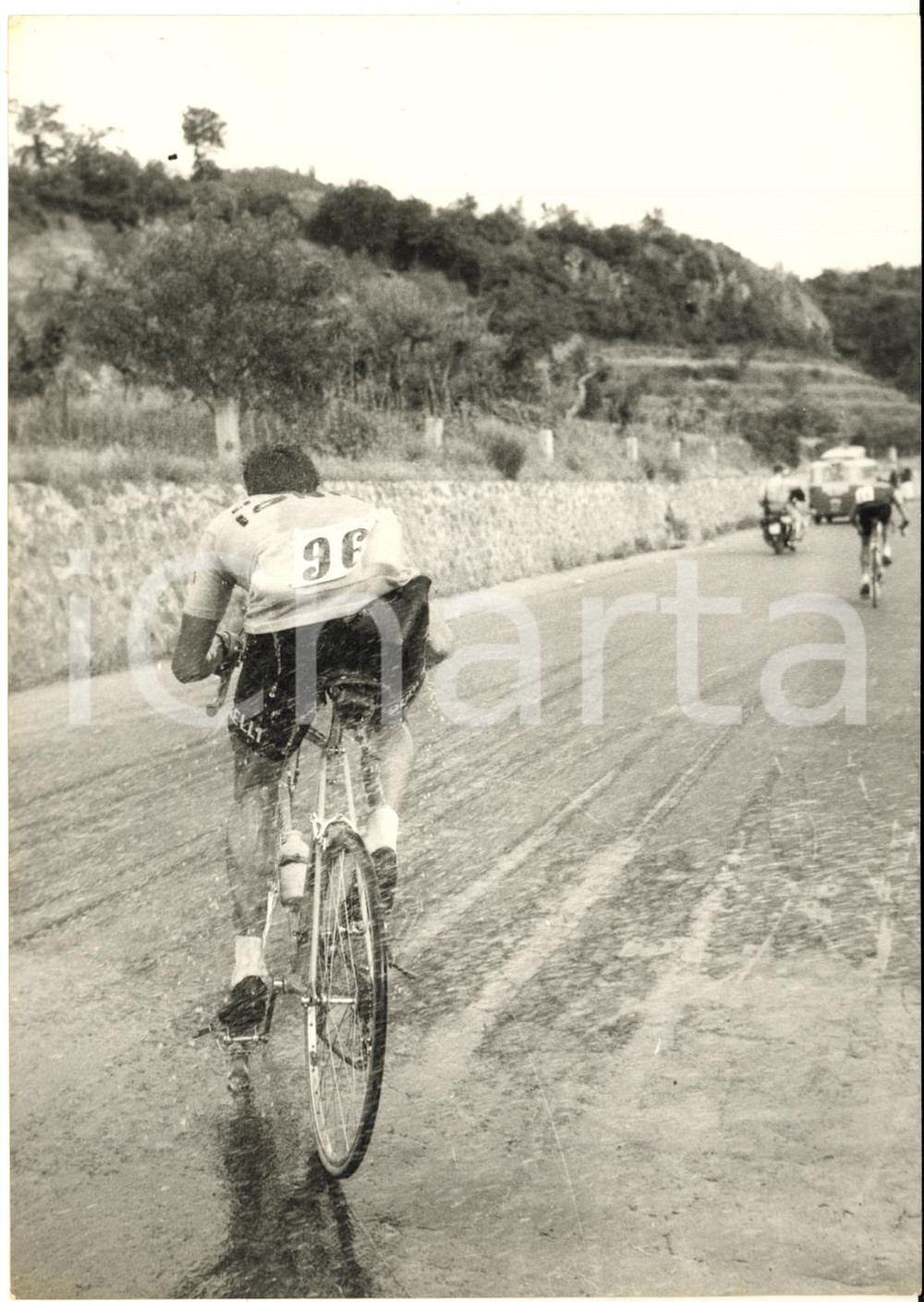 1955 ca CICLISMO GIRO D'ITALIA Rinfresco volante di Bruno TOGNACCINI *Foto 13x18  Fotografia d'epoca con didascalia coeva al verso.    CONDIZIONI: G (ma lieve sovraimpressione circolare)FORMATO: 13x18 cm     originale e autentica 1