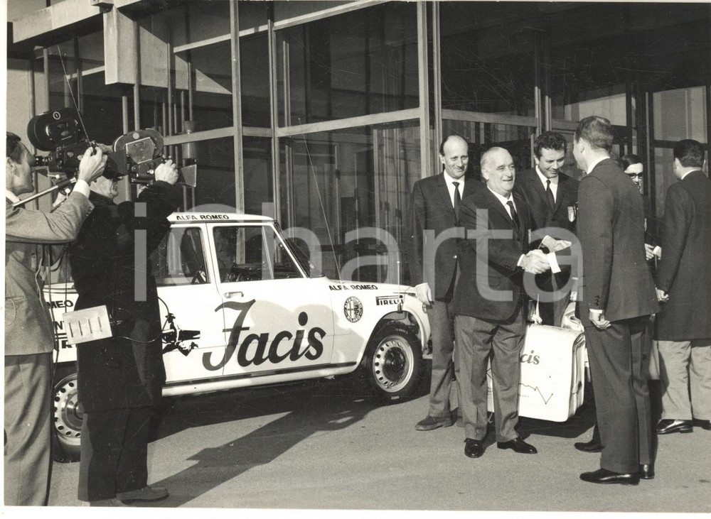 1967 MILANO Maner LUALDI con organizzatori raid Roma-Pechino - Alfa Romeo GIULIA Fotografia d'epoca con didascalia coeva al verso.Visibile una della Alfa Romeo Giulia destinata alla spedizione, con sponsor Facis. CONDIZIONI: GFORMATO: 18x13 cm     originale e autentica 1