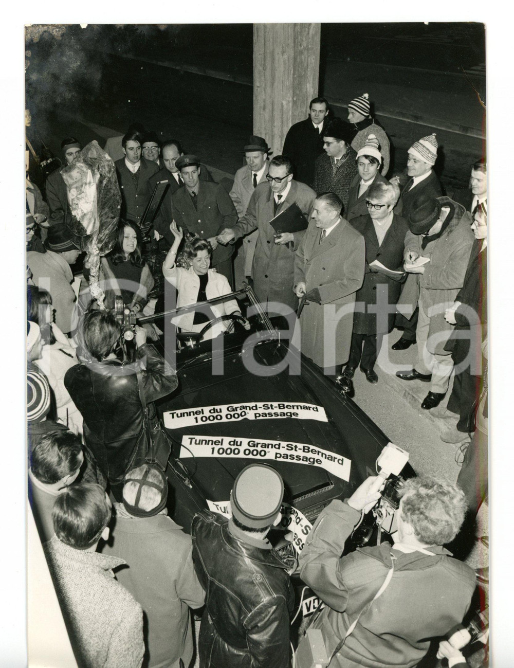 1967 AOSTA Milionesima vettura transitata dal traforo del GRAN SAN BERNARDO  Fotografia d'epoca con didascalia coeva al verso. CONDIZIONI: FAIR (macchie all'angolo superiore sinistro)FORMATO: 13x18 cm     originale e autentica 1