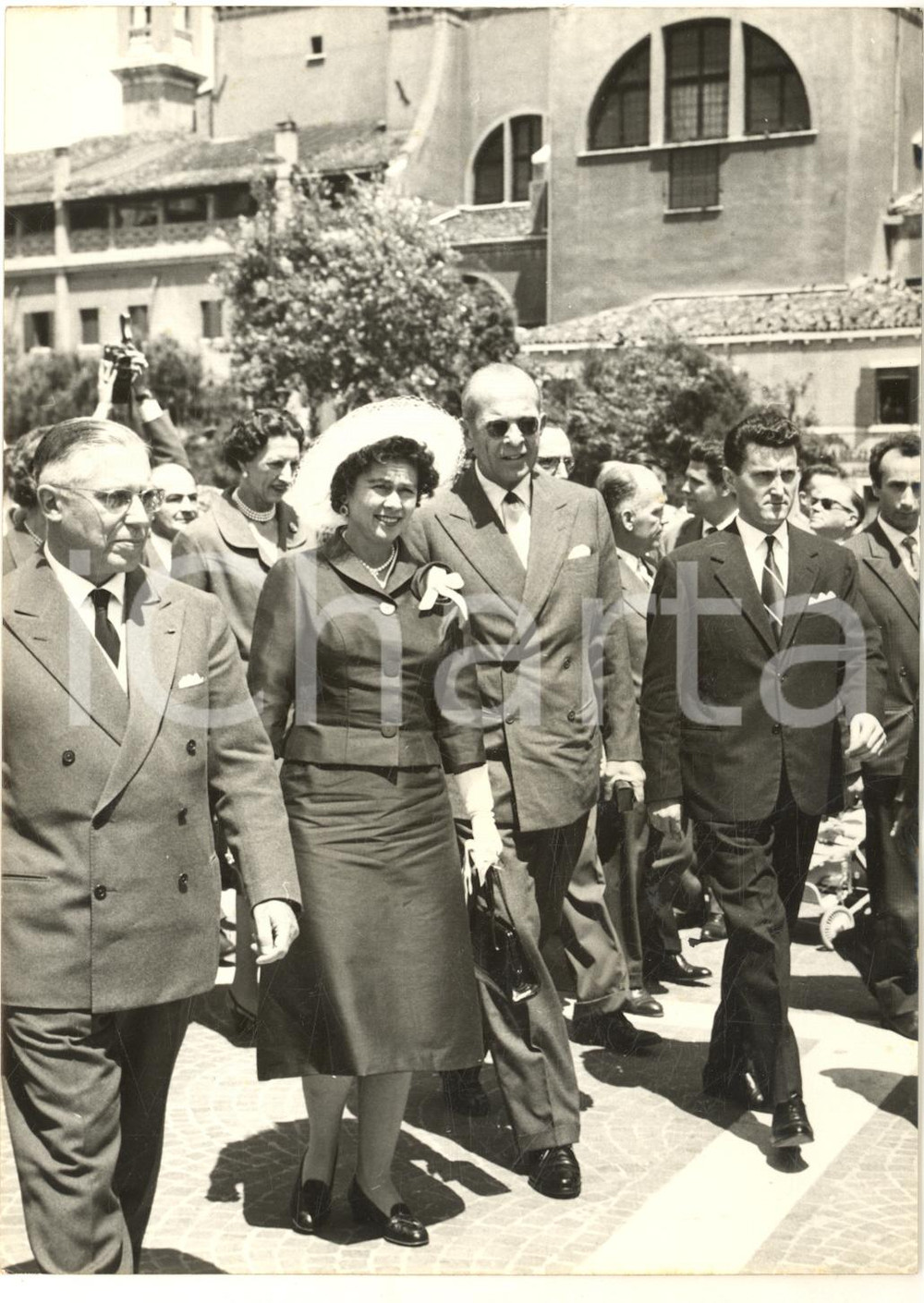 1959 VENEZIA Re Paolo e Federica di Grecia in arrivo a S. Lucia *Foto 13x18 Fotografia d'epoca, con didascalia coeva al verso. CONDIZIONI: FAIR (increspatura al lato destro; piccola macchia centrale)FORMATO: 13x18 cm     originale e autentica 1