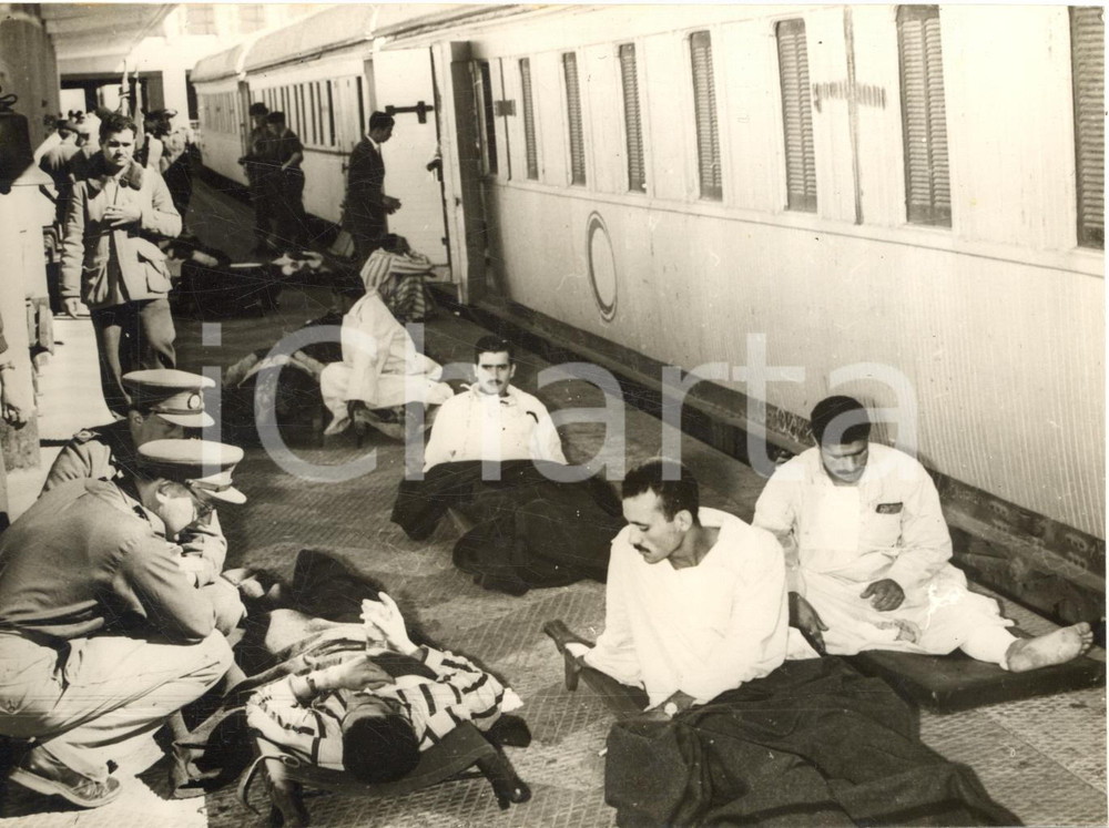 1950 PORTO SAID (EGITTO) Prigionieri feriti in attesa del treno per Il Cairo Fotografia d'epoca con didascalia coeva. CONDIZIONI: FAIR (sovraimpressioni)FORMATO: 18x13 cm     originale e autentica 1