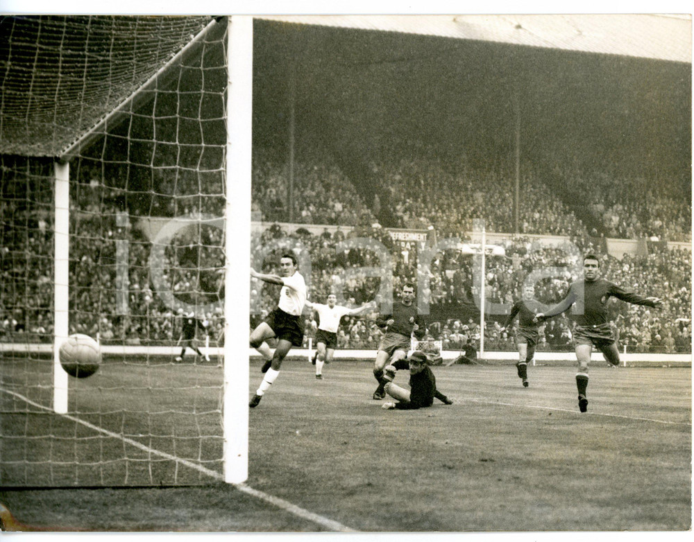 1960 WEMBLEY FOOTBALL - ENGLAND-SPAIN 4-1 Scored by Jimmy GREAVES *Foto 20x15 cm Fotografia d'epoca con didascalia coeva.  CONDIZIONI: FAIR (bassa qualit&agrave; di stampa e lieve alone diffuso) FORMATO: 20x15 cm     originale e autentica 1