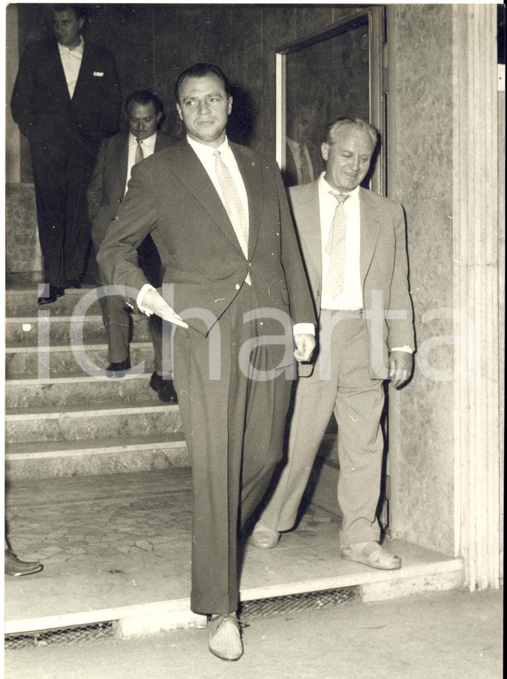 1957 MILANO BOXE Arrivo pugile Gerhard HECHT per incontro con Artenio CALZAVARA Fotografia d'epoca, con didascalia coeva al verso.  CONDIZIONI: FAIR (sovraimpressione al margine destro; lievi difetti di stampa) FORMATO: 13x18 cm    originale e autentica 1