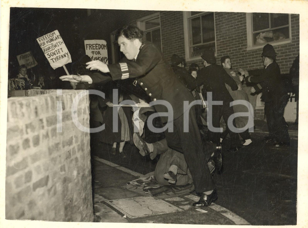 1956 LONDON Students demonstrate outside the "Daily Worker" office *Photo 20x15 Fotografia d'epoca con didascalia coeva.  CONDIZIONI: poor (piegature al margine sinistro e superiore; lievi ingiallimenti; sovraimpressione circolare) FORMATO:  20x15 cm     originale e autentica 1