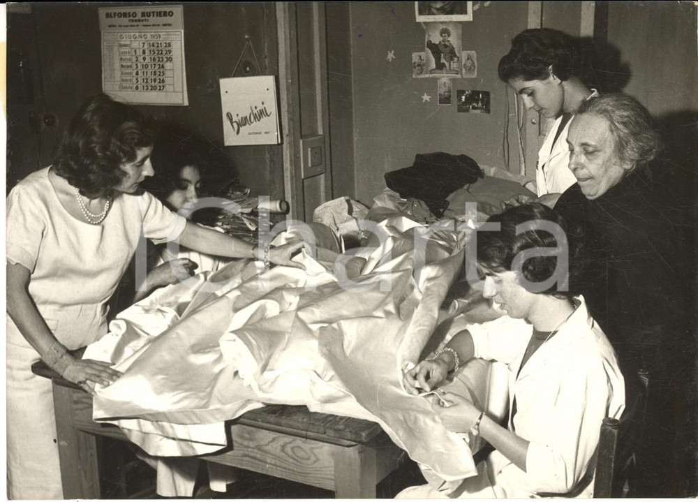 1959 NAPOLI Sarta Concetta BUONANNO cuce abito nuziale a Paola Ruffo di Calabria Fotografia d'epoca, con didascalia coeva. CONDIZIONI: G (ma increspatura al margine superiore)FORMATO: 18x13 cm     originale e autentica 1