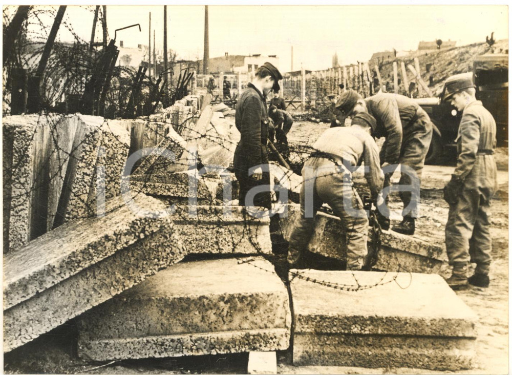 1962 BERLINO Poliziotti riparano porzione di muro abbattuta da famiglia in fuga