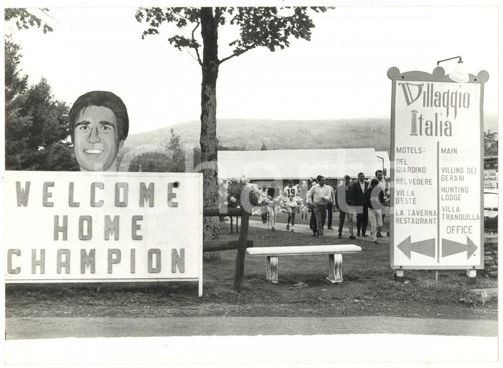 1967 BOXE NEW YORK VILLAGGIO ITALIA Cartelli di accoglienza per Nino BENVENUTI Fotografia d'epoca, con didascalia coeva al verso, scattata in occasione di una passeggiata del pugile in attesa del match con Emile Griffith.CONDIZIONI: FAIR (piegature al margine inferiore e all'angolo inferiore sinistro, lievi difetti di stampa e minima traccia d'inchiostro al margine inferiore)FORMATO: 18x13 cm    originale e autentica 1