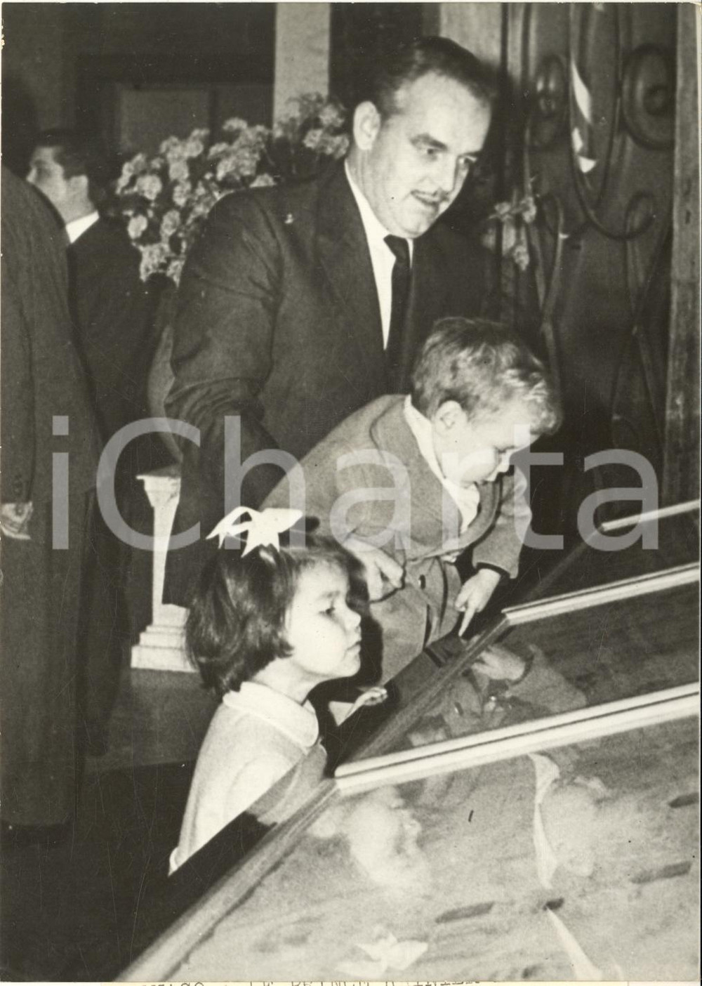 1960 MONACO Prince Rainier Ã  l'exposition des vitraux pour LES BAUX-DE-PROVENCE Fotografia d'epoca con didascalia coeva al verso, scattata in occasione della mostra delle vetrate offerte in dono alla chiesa locale.Sono ritratti i principi Caroline e Albert.CONDIZIONI: GFORMATO: 13x18 cm      originale e autentica 1