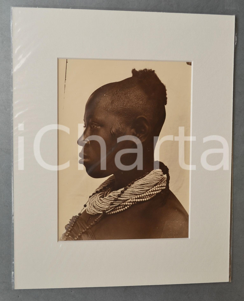 1950 ca AFRICA Ritratto donna di profilo con collane - Foto Jacques DONCQ 28x35  Fotografia originale d'epoca, incorniciata con passepartout in cartoncino pesante e fissata con adesivo al retro.Velina protettiva.FOTOGRAFO: Jacques DoncqCONDIZIONI: G (lievi difetti di stampa)FORMATO: 18x24 cm (fotografia); 28x35 cm (cartoncino)    originale e autentica 1