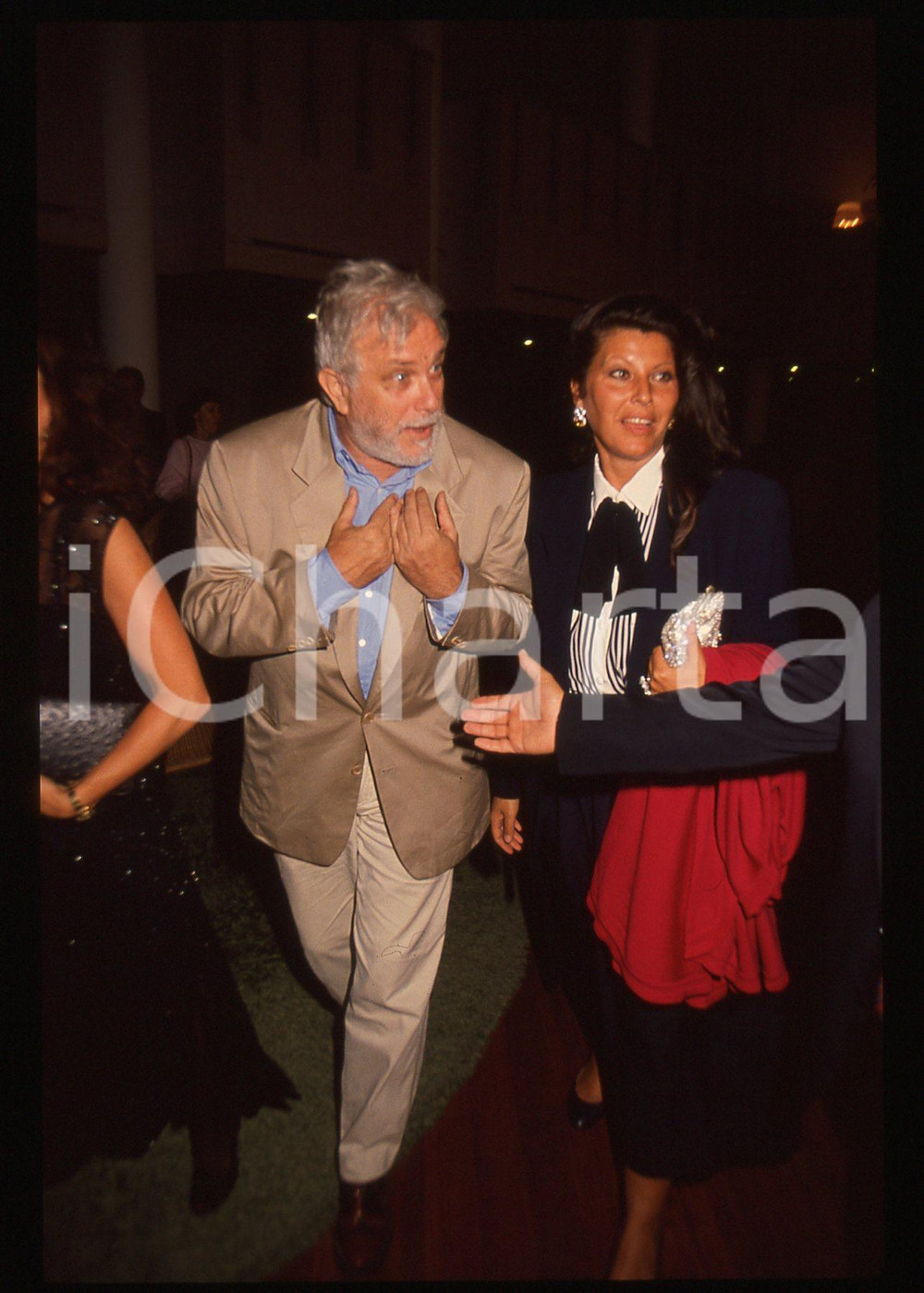 Luciano DE CRESCENZO e Claudia MORI - 1995 ca 35 mm vintage slide 3 Diapositiva d'epoca, in formato 35 mm.CONDIZIONI: GOODE' severamente vietata la riproduzione. Tutti i diritti sono riservati. ICharta mette in vendita, sul negozio eBay e in esclusiva sul sito "icharta" il proprio archivio composto da numerose diapositive e negativi fotografici d'epoca, tutti originali e autentici, che attraversano la storia del costume italiano tra gli la fine degli anni Sessanta e Novanta.Si tratta di uno sguardo inedito sull'attualità, la politica, la vita quotidiana, il gossip e la cultura, che fotografa il cambiamento della nazione in quest'ultimo scorcio del XX secolo. Un'occasione unica per il mercato del collezionismo, che vede finalmente disponibile un archivio eccezionale per vastità, tematiche e condizioni, in un settore (il negativo fotografico e la diapositiva) di assoluta novità e dalle interessanti prospettive di investimento.  GOOD/buono   originale e autentica 1
