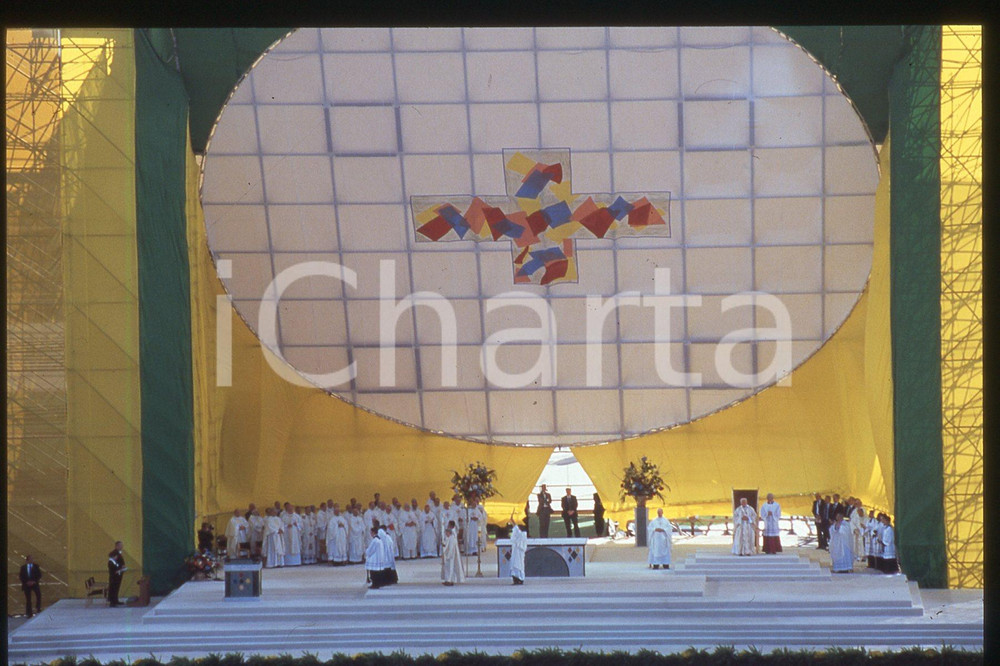 35mm vintage slide* 1995 BROOKLYN Aqueduct Racetrack - Giovanni Paolo II (4)  Diapositiva d'epoca, in formato 35 mm.CONDIZIONI: GOODE' severamente vietata la riproduzione. Tutti i diritti sono riservati.Nella diapositiva ICharta mette in vendita, sul negozio eBay e in esclusiva sul sito "icharta" il proprio archivio composto da numerose diapositive e negativi fotografici d'epoca, tutti originali e autentici, che attraversano la storia del costume italiano tra gli la fine degli anni Sessanta e Novanta.Si tratta di uno sguardo inedito sull'attualit&agrave;, la politica, la vita quotidiana, il gossip e la cultura, che fotografa il cambiamento della nazione in quest'ultimo scorcio del XX secolo. Un'occasione unica per il mercato del collezionismo, che vede finalmente disponibile un archivio eccezionale per vastit&agrave;, tematiche e condizioni, in un settore (il negativo fotografico e la diapositiva) di assoluta novit&agrave; e dalle interessanti prospettive di investimento.  FAIR/discreto   originale e autentica 1