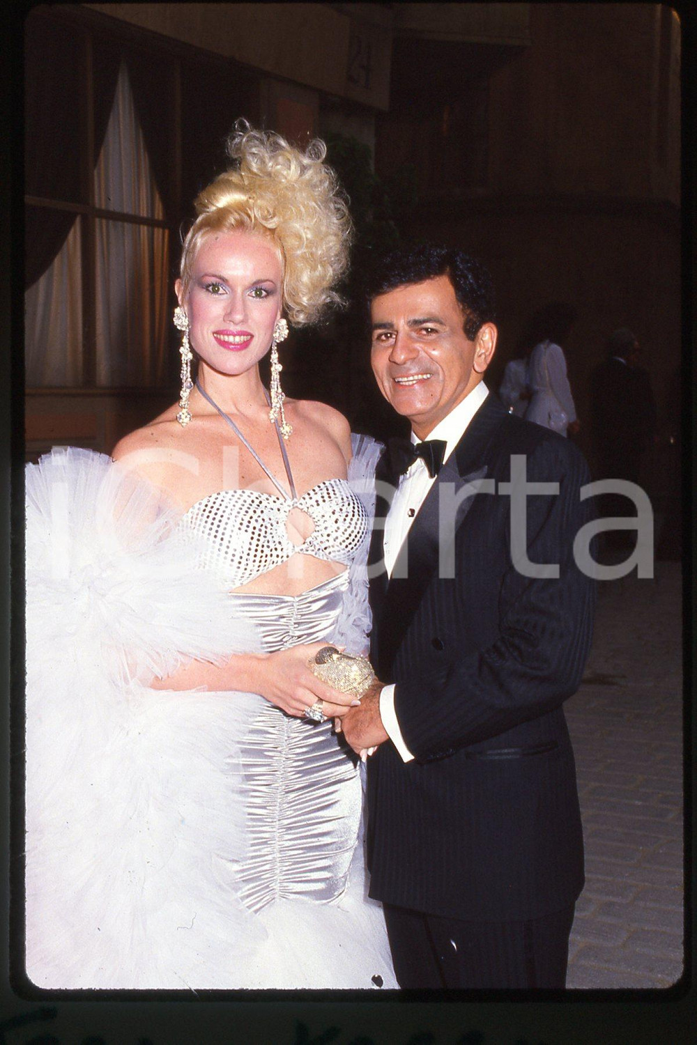 35mm vintage slide* 1987, California, an actress Jean Kasem with husband, Kasey  Diapositiva d'epoca, in formato 35 mm.CONDIZIONI: GOODE' severamente vietata la riproduzione. Tutti i diritti sono riservati.Nella diapositiva ICharta mette in vendita, sul negozio eBay e in esclusiva sul sito "icharta" il proprio archivio composto da numerose diapositive e negativi fotografici d'epoca, tutti originali e autentici, che attraversano la storia del costume italiano tra gli la fine degli anni Sessanta e Novanta.Si tratta di uno sguardo inedito sull'attualit&agrave;, la politica, la vita quotidiana, il gossip e la cultura, che fotografa il cambiamento della nazione in quest'ultimo scorcio del XX secolo. Un'occasione unica per il mercato del collezionismo, che vede finalmente disponibile un archivio eccezionale per vastit&agrave;, tematiche e condizioni, in un settore (il negativo fotografico e la diapositiva) di assoluta novit&agrave; e dalle interessanti prospettive di investimento.  FAIR/discreto   originale e autentica 1