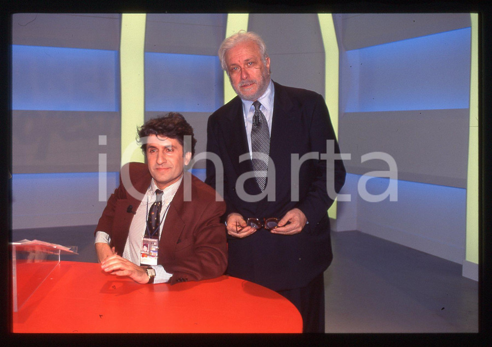 Luciano DE CRESCENZO Gianni IPPOLITI FESTIVAL SANREMO 1995 35 mm vintage slide Diapositiva d'epoca, in formato 35 mm.CONDIZIONI: GOODE' severamente vietata la riproduzione. Tutti i diritti sono riservati.ICharta mette in vendita, sul negozio eBay e in esclusiva sul sito "icharta" il proprio archivio composto da numerose diapositive e negativi fotografici d'epoca, tutti originali e autentici, che attraversano la storia del costume italiano tra gli la fine degli anni Sessanta e Novanta.Si tratta di uno sguardo inedito sull'attualità, la politica, la vita quotidiana, il gossip e la cultura, che fotografa il cambiamento della nazione in quest'ultimo scorcio del XX secolo. Un'occasione unica per il mercato del collezionismo, che vede finalmente disponibile un archivio eccezionale per vastità, tematiche e condizioni, in un settore (il negativo fotografico e la diapositiva) di assoluta novità e dalle interessanti prospettive di investimento.  GOOD/buono   originale e autentica 1