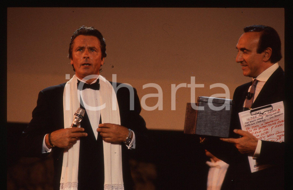 Alain DELON e Pippo BAUDO - TEATRO GRECO TAORMINA 1989 35 mm vintage slide Diapositiva d'epoca, in formato 35 mm.CONDIZIONI: GOODE' severamente vietata la riproduzione. Tutti i diritti sono riservati.ICharta mette in vendita, sul negozio eBay e in esclusiva sul sito "icharta" il proprio archivio composto da numerose diapositive e negativi fotografici d'epoca, tutti originali e autentici, che attraversano la storia del costume italiano tra gli la fine degli anni Sessanta e Novanta.Si tratta di uno sguardo inedito sull'attualità, la politica, la vita quotidiana, il gossip e la cultura, che fotografa il cambiamento della nazione in quest'ultimo scorcio del XX secolo. Un'occasione unica per il mercato del collezionismo, che vede finalmente disponibile un archivio eccezionale per vastità, tematiche e condizioni, in un settore (il negativo fotografico e la diapositiva) di assoluta novità e dalle interessanti prospettive di investimento.  GOOD/buono   originale e autentica 1