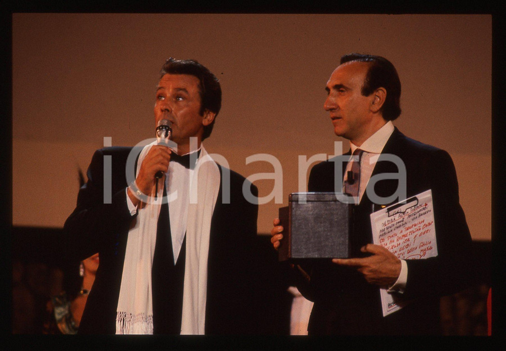 Alain DELON e Pippo BAUDO - TEATRO GRECO TAORMINA 1989 35 mm vintage slide 5 Diapositiva d'epoca, in formato 35 mm.CONDIZIONI: GOODE' severamente vietata la riproduzione. Tutti i diritti sono riservati.ICharta mette in vendita, sul negozio eBay e in esclusiva sul sito "icharta" il proprio archivio composto da numerose diapositive e negativi fotografici d'epoca, tutti originali e autentici, che attraversano la storia del costume italiano tra gli la fine degli anni Sessanta e Novanta.Si tratta di uno sguardo inedito sull'attualità, la politica, la vita quotidiana, il gossip e la cultura, che fotografa il cambiamento della nazione in quest'ultimo scorcio del XX secolo. Un'occasione unica per il mercato del collezionismo, che vede finalmente disponibile un archivio eccezionale per vastità, tematiche e condizioni, in un settore (il negativo fotografico e la diapositiva) di assoluta novità e dalle interessanti prospettive di investimento.  GOOD/buono   originale e autentica 1