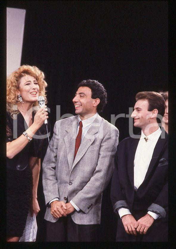 Michele ALBORETO Gabriella CARLUCCI Ferrari 1985 ca - 35 mm vintage slide Diapositiva d'epoca, in formato 35 mm. E' severamente vietata la riproduzione. Tutti i diritti sono riservati.  ICharta mette in vendita, sul negozio eBay e in esclusiva sul sito "icharta" il proprio archivio composto da numerose diapositive e negativi fotografici d'epoca, tutti originali e autentici, che attraversano la storia del costume tra la fine degli anni Sessanta e Novanta.Si tratta di uno sguardo inedito sull'attualit&agrave;, la politica, la vita quotidiana, il gossip e la cultura, che fotografa il cambiamento della nazione in quest'ultimo scorcio del XX secolo. Un'occasione unica per il mercato del collezionismo, che vede finalmente disponibile un archivio eccezionale per vastit&agrave;, tematiche e condizioni, in un settore (il negativo fotografico e la diapositiva) di assoluta novit&agrave; e dalle interessanti prospettive di investimento.  GOOD/buono   originale e autentica 1