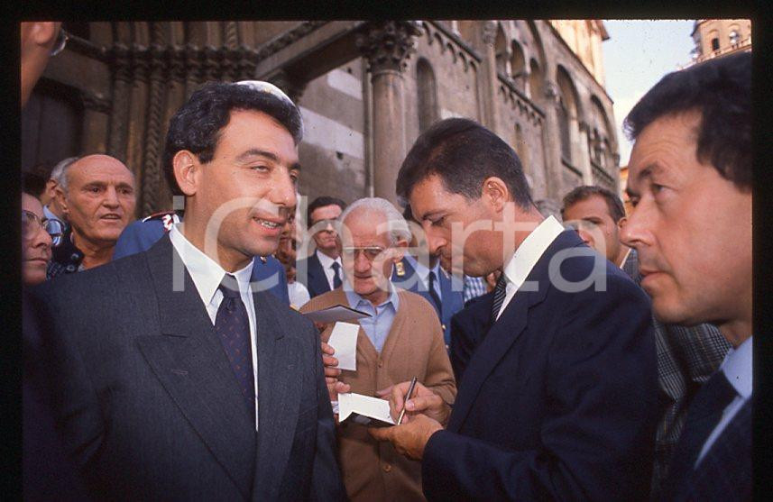 Michele ALBORETO Piero LARDI FERRARI 1985 ca - 35 mm vintage slide Diapositiva d'epoca, in formato 35 mm. E' severamente vietata la riproduzione. Tutti i diritti sono riservati.  ICharta mette in vendita, sul negozio eBay e in esclusiva sul sito "icharta" il proprio archivio composto da numerose diapositive e negativi fotografici d'epoca, tutti originali e autentici, che attraversano la storia del costume tra la fine degli anni Sessanta e Novanta.Si tratta di uno sguardo inedito sull'attualit&agrave;, la politica, la vita quotidiana, il gossip e la cultura, che fotografa il cambiamento della nazione in quest'ultimo scorcio del XX secolo. Un'occasione unica per il mercato del collezionismo, che vede finalmente disponibile un archivio eccezionale per vastit&agrave;, tematiche e condizioni, in un settore (il negativo fotografico e la diapositiva) di assoluta novit&agrave; e dalle interessanti prospettive di investimento.  GOOD/buono   originale e autentica 1