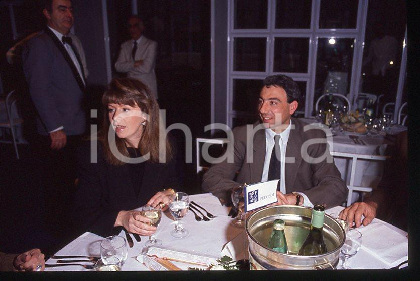 Michele ALBORETO con la moglie Nadia ASTORRI 1985 ca - 35 mm vintage slide (4) Diapositiva d'epoca, in formato 35 mm. E' severamente vietata la riproduzione. Tutti i diritti sono riservati.  ICharta mette in vendita, sul negozio eBay e in esclusiva sul sito "icharta" il proprio archivio composto da numerose diapositive e negativi fotografici d'epoca, tutti originali e autentici, che attraversano la storia del costume tra la fine degli anni Sessanta e Novanta.Si tratta di uno sguardo inedito sull'attualit&agrave;, la politica, la vita quotidiana, il gossip e la cultura, che fotografa il cambiamento della nazione in quest'ultimo scorcio del XX secolo. Un'occasione unica per il mercato del collezionismo, che vede finalmente disponibile un archivio eccezionale per vastit&agrave;, tematiche e condizioni, in un settore (il negativo fotografico e la diapositiva) di assoluta novit&agrave; e dalle interessanti prospettive di investimento.  GOOD/buono   originale e autentica 1